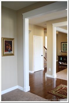 an empty living room with hardwood floors and white trim on the walls is seen in this image