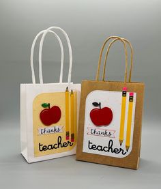 two paper bags with pencils and an apple on them, one is for teacher