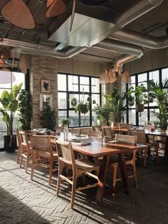 an empty restaurant with large windows and wooden tables set up for people to sit at