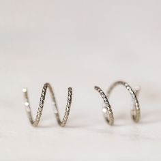 Tiny Double Hoop Earrings, Minimal Spiral Earrings, Tiny Twist Earrings, Double Hoop Earrings, Double Piercing, Diamond Cut Hoop EarringsTwist these little coils in and instantly get the appearance of two lobe piercings.(You only need ONE piercing to make these work-- they give the look of two!)(It can also be worn with two holes in case you have them)All you do is thread one side through your first hoop until the other side sits comfortably on your earlobe giving the illusion of a second hole. Silver Spiral Cartilage Earrings As Gift, Adjustable Silver Spiral Cartilage Earrings, Silver Spiral Hoop Earrings With Ear Wire, Hypoallergenic Spiral Earrings For Everyday, Spiral Nickel-free Hoop Earrings For Everyday, Silver Spiral Hoop Earrings, Silver Spiral Hoop Earrings For Everyday, Everyday Spiral Silver Hoop Earrings, Everyday Silver Spiral Hoop Earrings