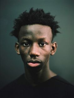 a young man with black hair looking at the camera