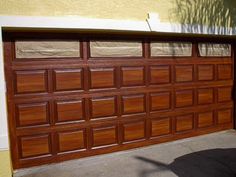 a brown garage door in front of a yellow building