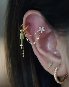 a close up of a person's ear with three different types of piercings