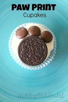 an oreo cookie sitting on top of a blue plate with the words paw print cupcakes