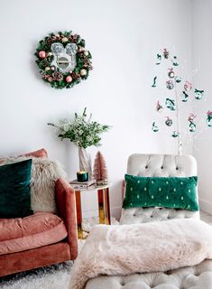 a living room with two couches and a christmas wreath on the wall above them