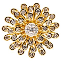 18k yellow gold ring. This delightful ring is a large zinnia flower motif, with a center featuring a princess cut diamonds, surrounded by four marquise brilliant diamonds, framed by a spray of petals, each set with a round brilliant cut diamond. The total diamond weight for the ring is 1.60 TCW. Marks: 18k Dimensions: 15/16" diameter Weight: 7.8 gross dwt Luxury Yellow Gold Flower Ring With Brilliant Cut, Luxury Yellow Gold Flower Ring With Prong Setting, Luxury Yellow Gold Flower Ring With Center Stone, Luxury Yellow Gold Flower Diamond Ring, Luxury Gold Flower Diamond Ring, Luxury Flower Shaped Yellow Gold Diamond Ring, Exquisite Gold Diamond Flower Ring, Flower Cluster Ring, Zinnia Flower