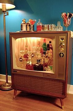 an old fashioned television with liquor bottles on top