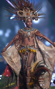 a woman in an elaborate costume on the runway