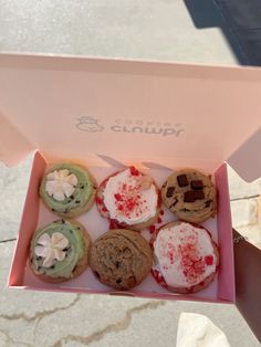 a pink box filled with different types of cookies