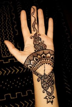 a person's hand with a henna tattoo on the palm and wrist area