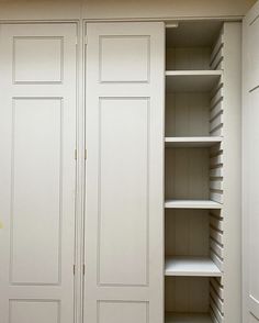 an empty white closet with shelves and drawers