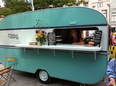 a person sitting at a table in front of a food truck