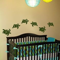 a baby's room with turtle decals on the wall and a crib