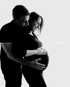 a pregnant man and woman embracing each other