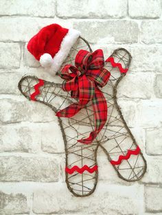 a teddy bear with a santa hat on it's head hanging on a brick wall