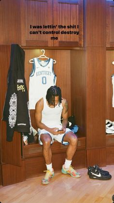 a man sitting in a locker with his shoes on