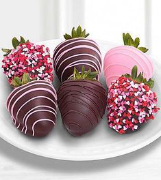 three chocolate covered strawberries on a white plate