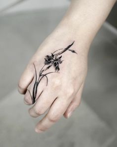 a woman's hand with a flower tattoo on it