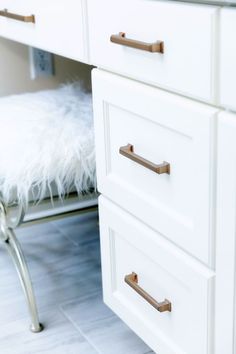 a white dresser with brass handles and drawers