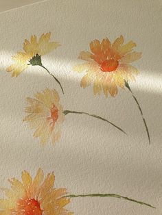 watercolor painting of three yellow flowers on white paper with sunlight coming through the window