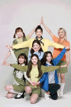 a group of young women standing next to each other in front of a white background