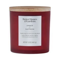 a red candle with a wooden lid and label on the top that says, better homes & gardens amber saffron