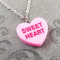 "This listing is for a pink sweetheart candy heart charm necklace. You'll be able to choose your chain length and style at checkout by using the \"Chain Length/Style\" drop-down menu. Keyrings, bangle bracelets, ball chains, and black/brown leather and suede cord are also available. **Please see the second photo for scale! If you're on the mobile site, just swipe to the side. :) ITEM CARE: Avoid contact with water, for best results. - - - - - - - Sign up for our newsletter to receive coupons and updates on new items! Follow the link: ♦ ♦ ♦ http://eepurl.com/cG7GGT ♦ ♦ ♦ - - - - - - - This is our third shop for jewelry. If you're looking for something a bit more \"personalized\", then just follow these links: www.etsy.com/shop/metalspeak www.etsy.com/shop/metalspeaktoo - - - - - - - Thank y Personalized Pink Charm Necklace As Gift, Novelty Necklaces For Valentine's Day Gift, Sweet Nickel-free Jewelry For Gifts, Sweet Nickel-free Jewelry Gift, Sweet Pink Nickel-free Jewelry, Cute Necklace For Birthday And Valentine's Day, Sweet Silver Necklace Perfect For Gifts, Sweet Pink Necklaces For Valentine's Day, Pink Heart Charm Necklace With Heart Pendant