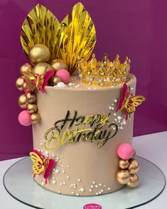 a birthday cake decorated with gold and pink decorations