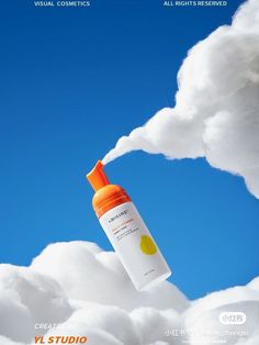 an orange bottle floating in the air on top of clouds with blue sky behind it