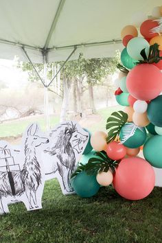 a bunch of balloons that are on some grass