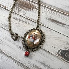 Here is a handmade necklace that was made using a rare mustard and red acrylic lovers cameo. The cameo is made in a fun French baroque style. It is made form an acrylic. It is set in a scalloped edge setting with a vintage red rhinestone dangle. The pendant hangs on an antique brass chain that closes with a lobster claw clasp.Size Pendant 2 7/8 by 1 7/8 inches Chain 25 inches Vintage Red Oval Pendant Necklace, Red Oval Pendant Vintage Necklace, Red Vintage Oval Pendant Necklace, Red Vintage Necklace With Charm, Red Cameo Necklace For Gift, Red Vintage Locket Necklace, Vintage Red Round Pendant Necklace, Vintage Red Locket Necklace, French Baroque