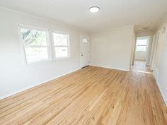 an empty room with hard wood floors and white walls