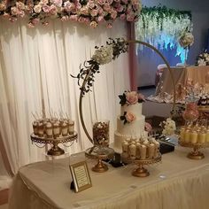 a table topped with lots of cakes and cupcakes on top of a table