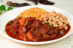 a white plate topped with meat and beans