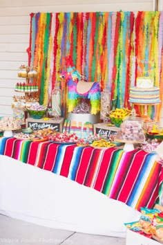 a table filled with lots of colorful desserts and candy bar decorations on top of it