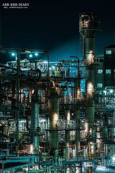 an oil refinery lit up at night with lots of pipes