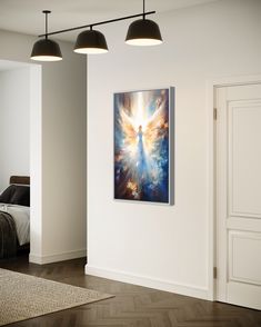 an angel painting hanging on the wall in a room with wood floors and white walls