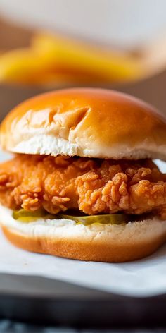 a fried chicken sandwich on a bun with pickles