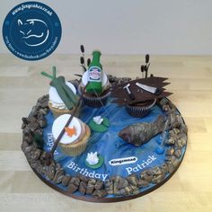 a birthday cake with cupcakes and decorations on the top is made to look like an ocean scene