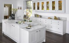 an image of a kitchen with white cabinets and wood flooring in the middle of it