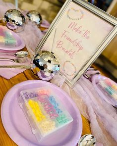 a table topped with pink plates and silverware