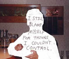 a man in a white jacket with writing on his shirt that says, i still blame my self for things i couldn't control