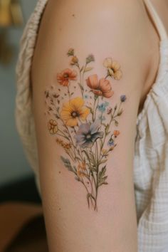 a woman's arm with flowers painted on the back of her shoulder and chest