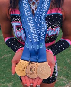 a woman holding two medals in her hands