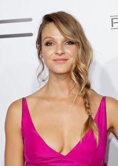 a woman in a pink dress with braids on her head and eyes closed, posing for the camera