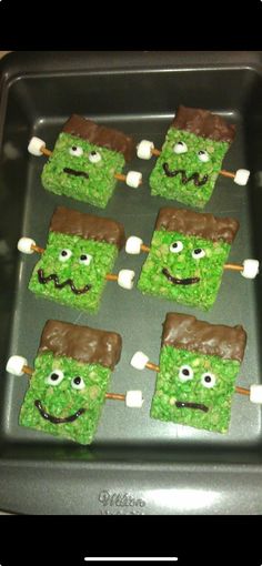 green marshmallows with chocolate and marshmallow faces on them in a baking pan