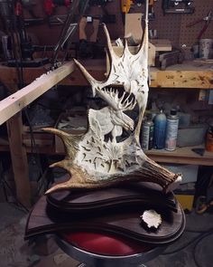 an animal's head is sitting on top of several pieces of wood in a workshop