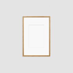 a white wall with a gold frame hanging on it's side, and an empty square in the middle