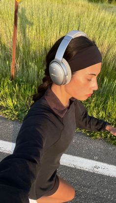 a woman with headphones is walking down the street