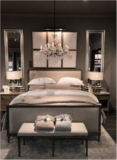 a large bed sitting in a bedroom under a chandelier